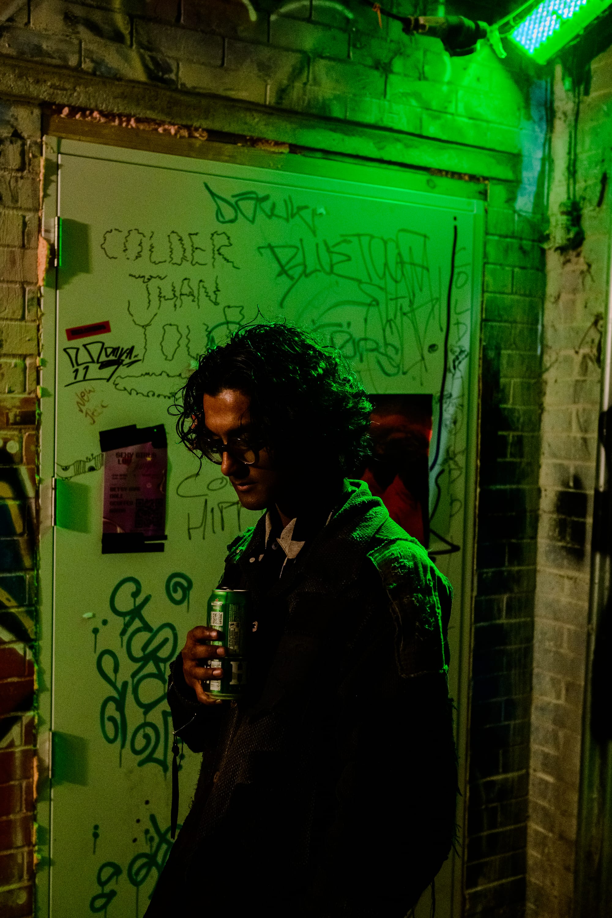 A person in the smoking area bathed in green light.