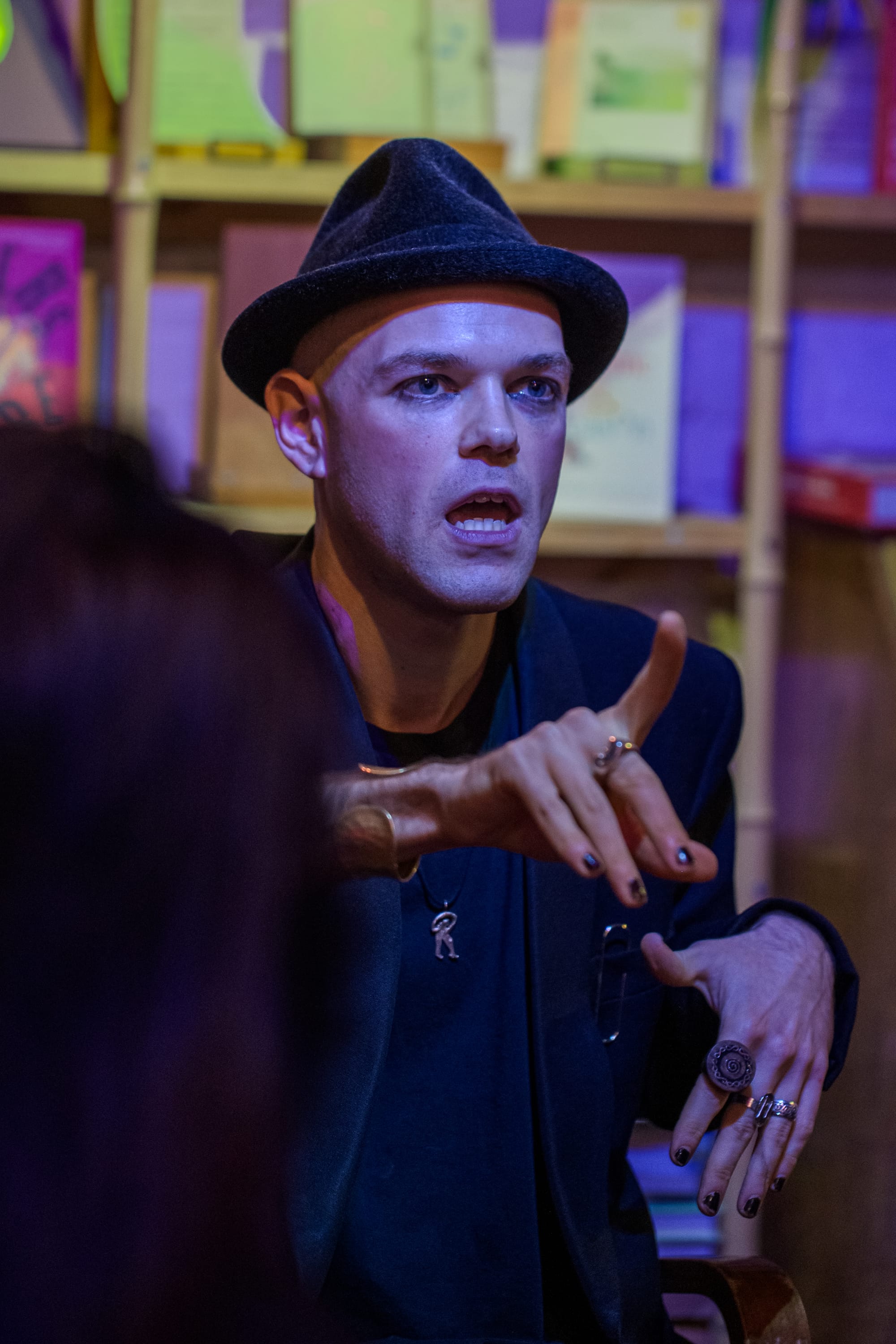 A performer in a hat and rings.