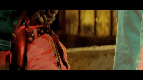 A man appearing to threaten another man with a knife, but then dropping it in the ground.