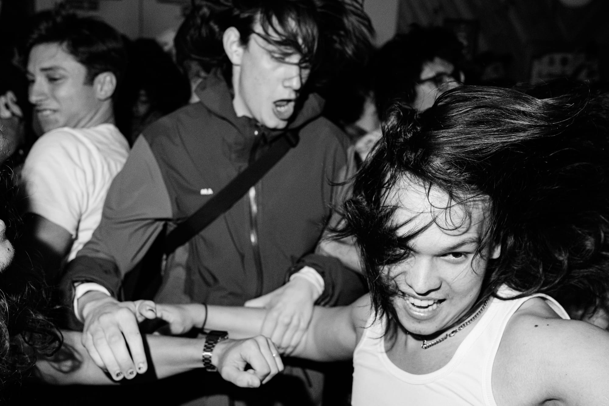 Three people moshing at the Protomartyr gig.