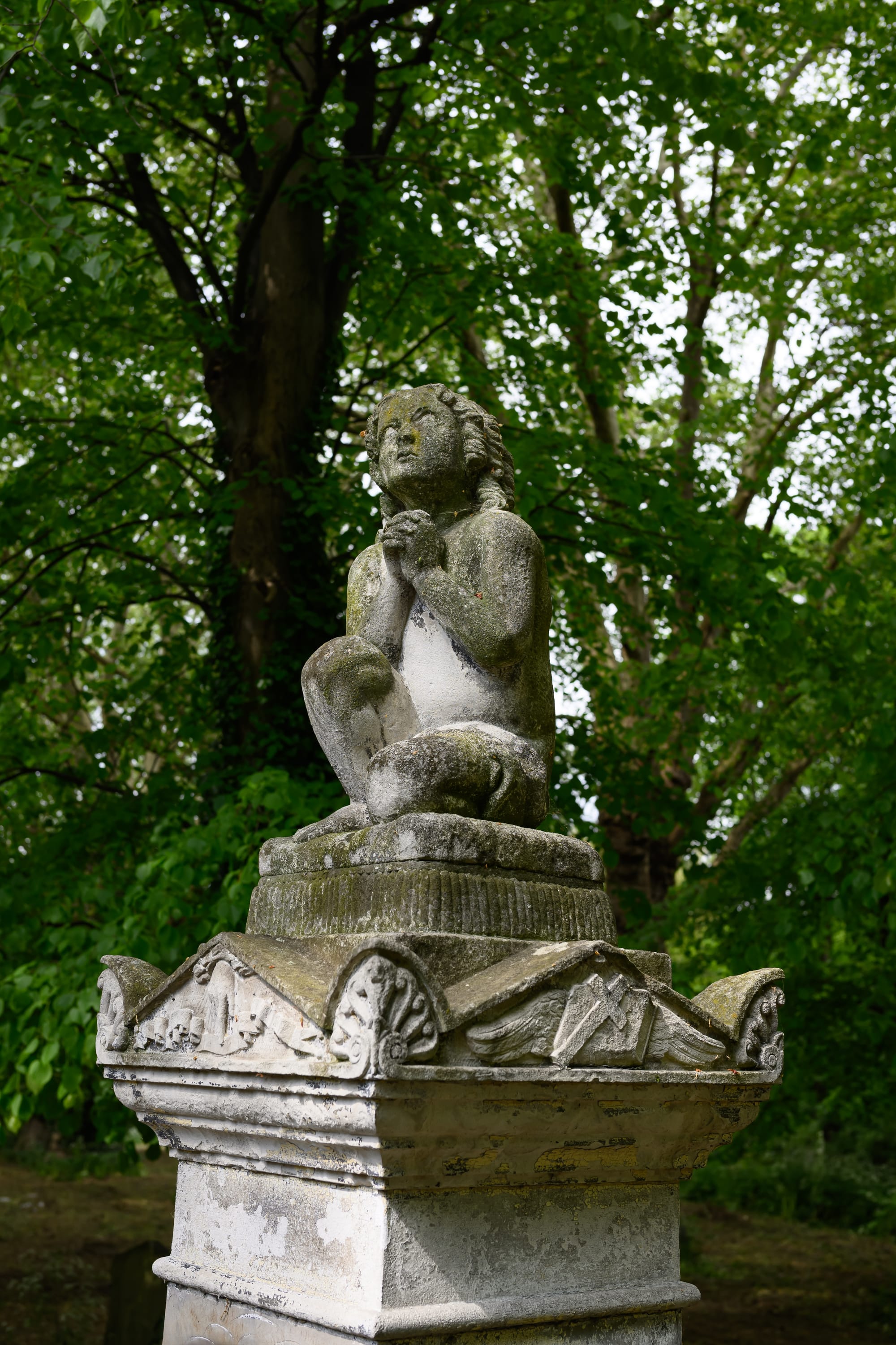 A statue with its hands clasped in prayer.