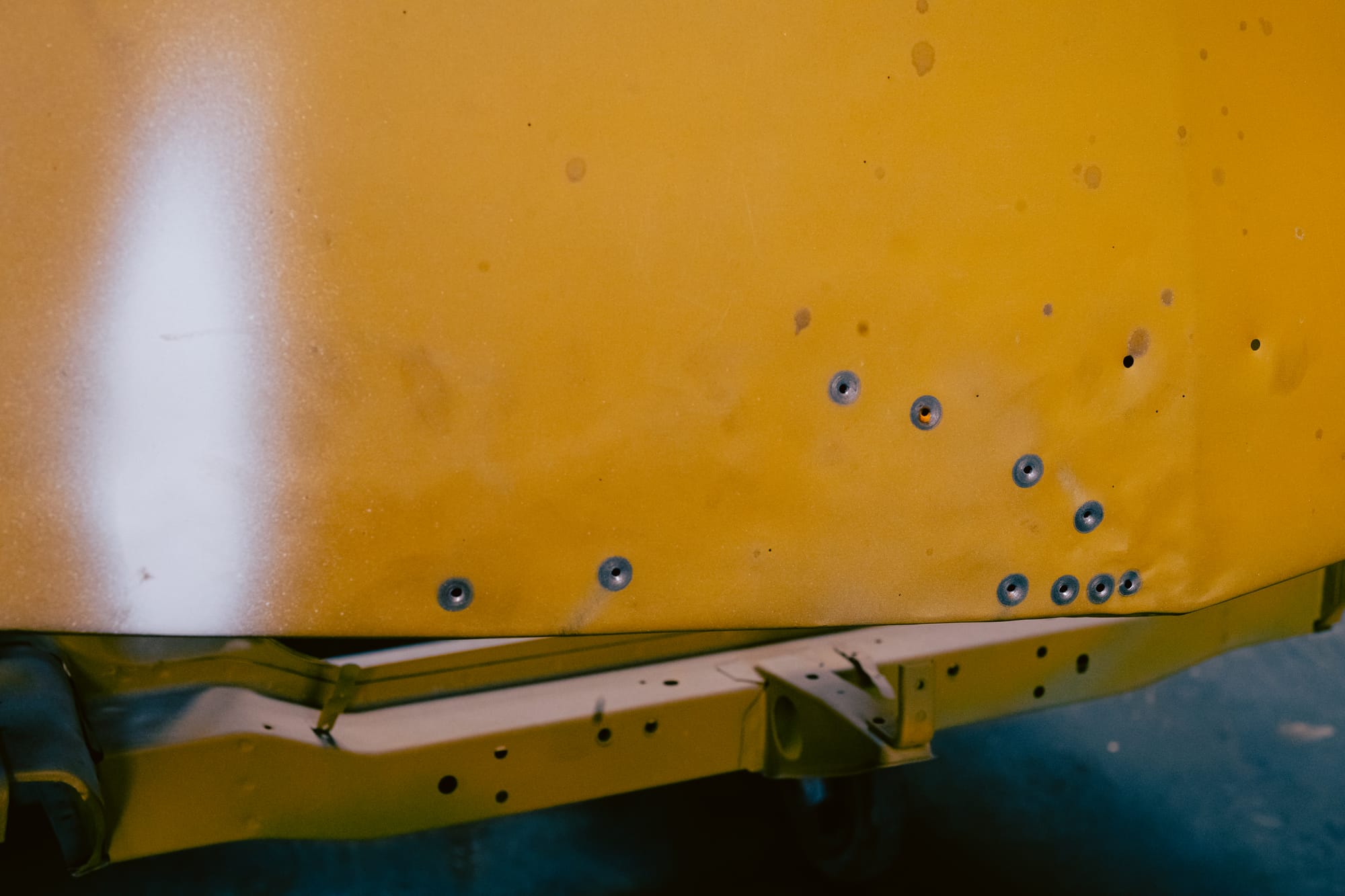 Pockmarks and spraypaint on a Datsun 240Z bonnet.